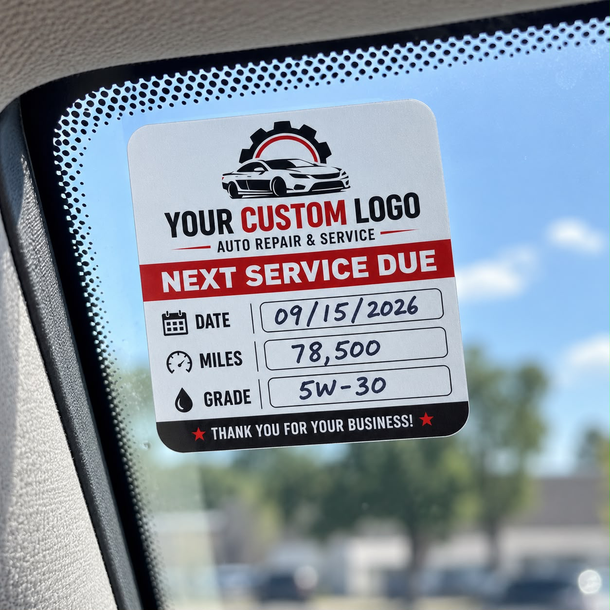 Oil change reminder sticker on a car windshield